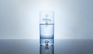 Abstract water drop splash inside glass half full against bright background. Purity and health concept